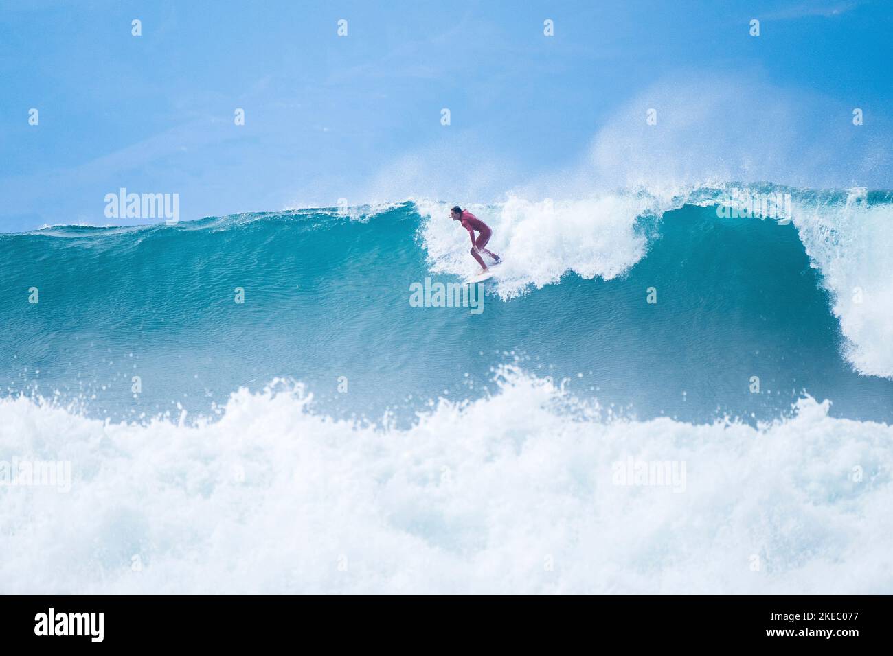 un uomo che cavalca una grande ed estrema onda blu nell'oceano - tempo di estate e godendo le vacanze Foto Stock