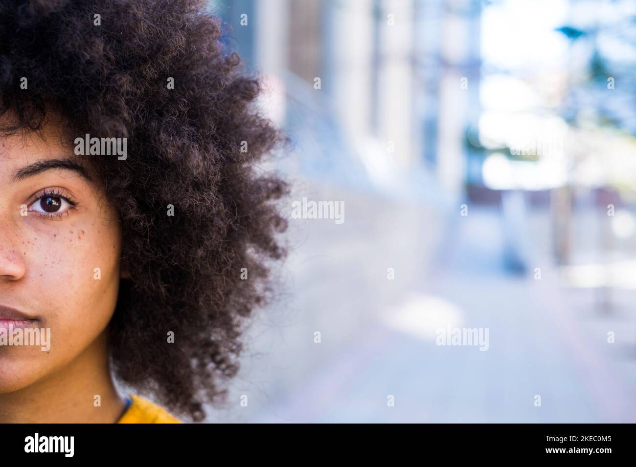 Ritratto di mezzo volto di una giovane bella donna africana o americana guardando la fotocamera. Primo piano di occhio di ragazza afro, copia e spazio vuoto Foto Stock