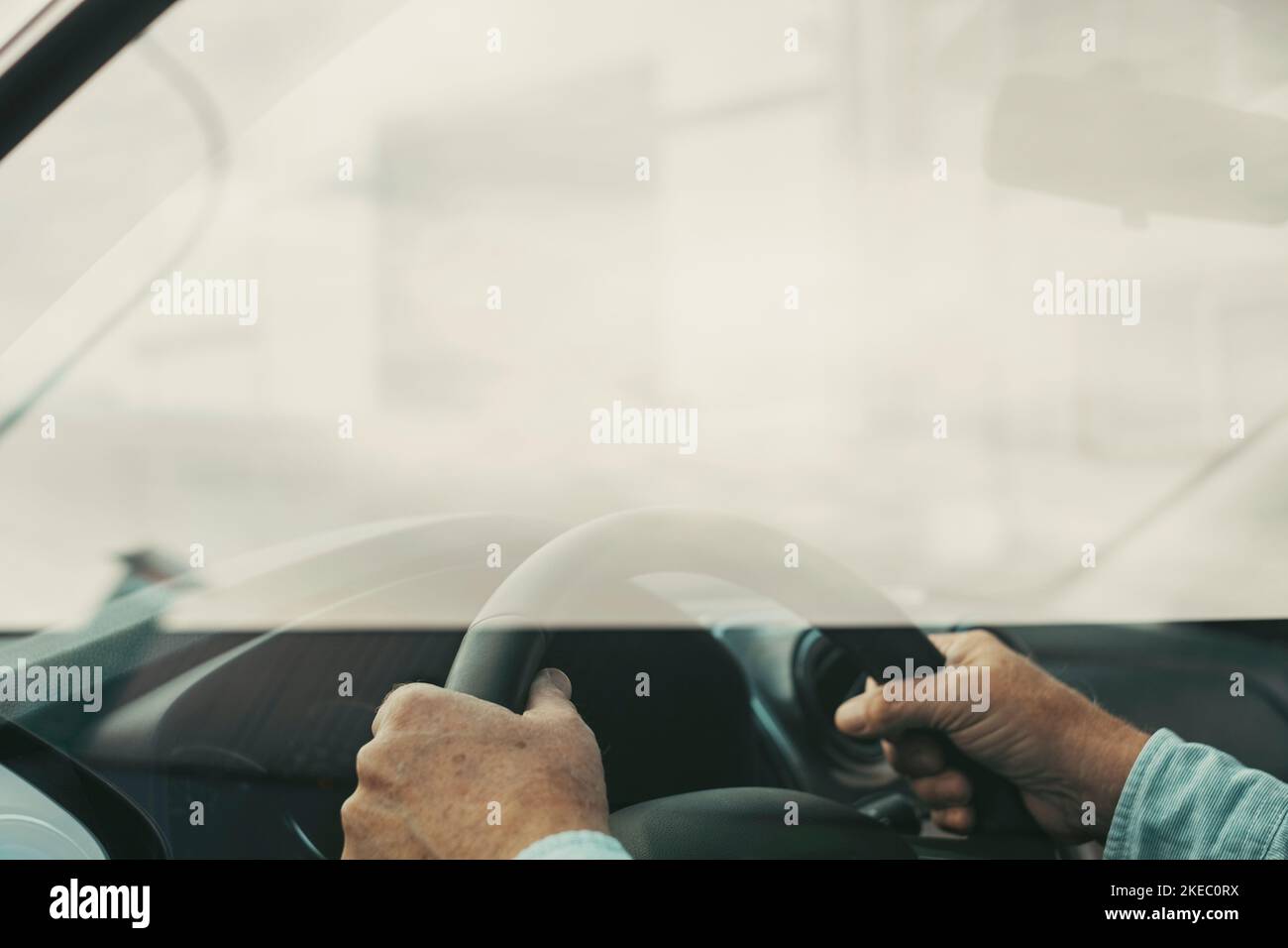 Primo piano e ritratto di un vecchio e pensionato che tiene il volante con le mani alla guida e che si diverte con una nuova vettura su strada. Concetto di cliente soddisfatto Foto Stock
