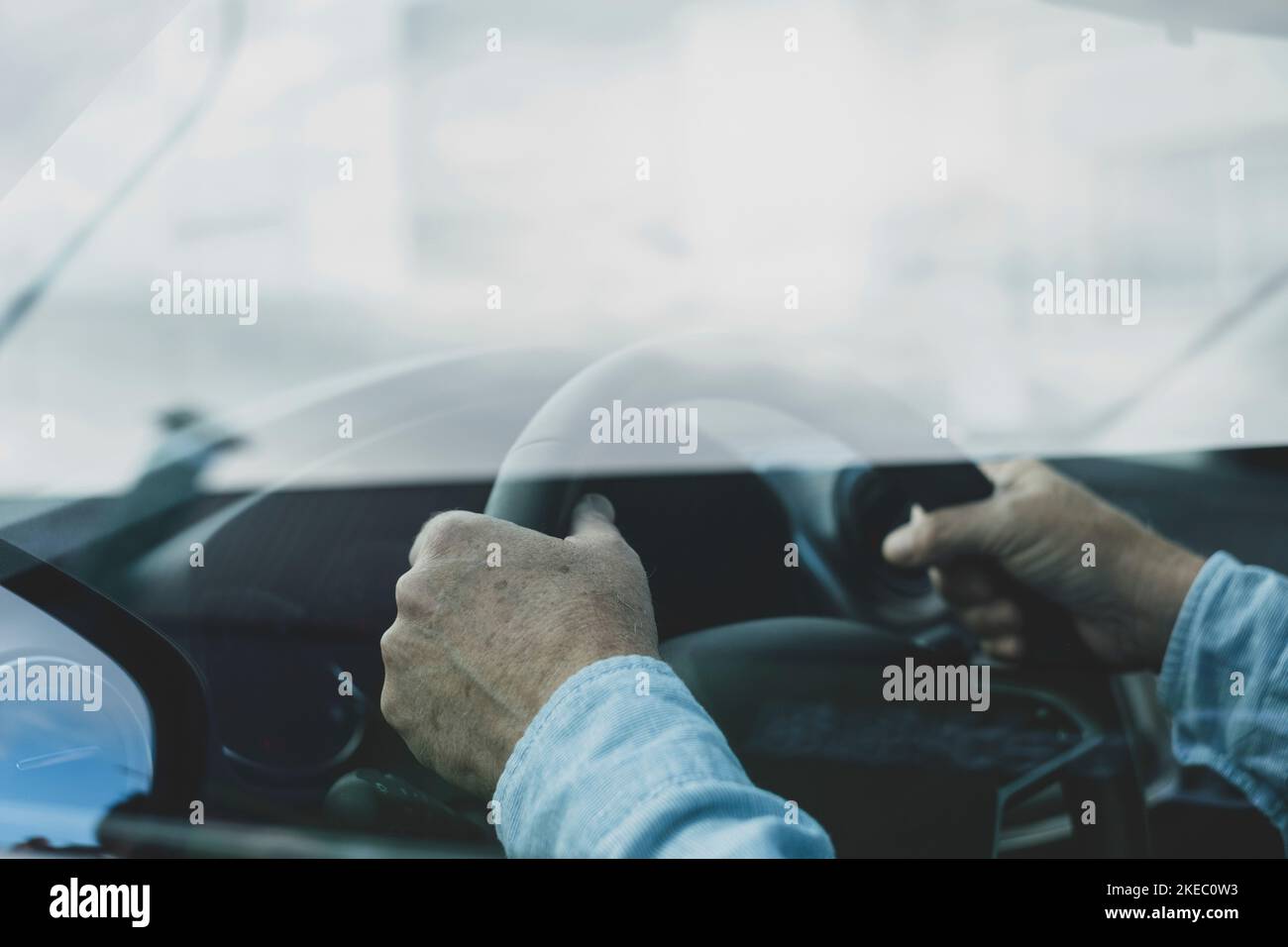 Primo piano e ritratto di un vecchio e pensionato che tiene il volante con le mani alla guida e che si diverte con una nuova vettura su strada. Concetto di cliente soddisfatto Foto Stock