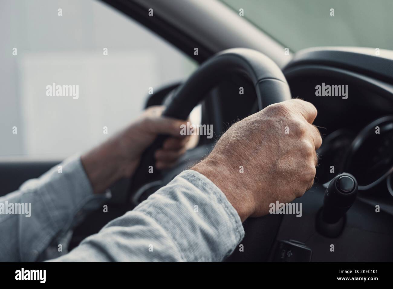Primo piano e ritratto di un vecchio e pensionato che tiene il volante con le mani alla guida e che si diverte con una nuova vettura su strada. Concetto di cliente soddisfatto Foto Stock