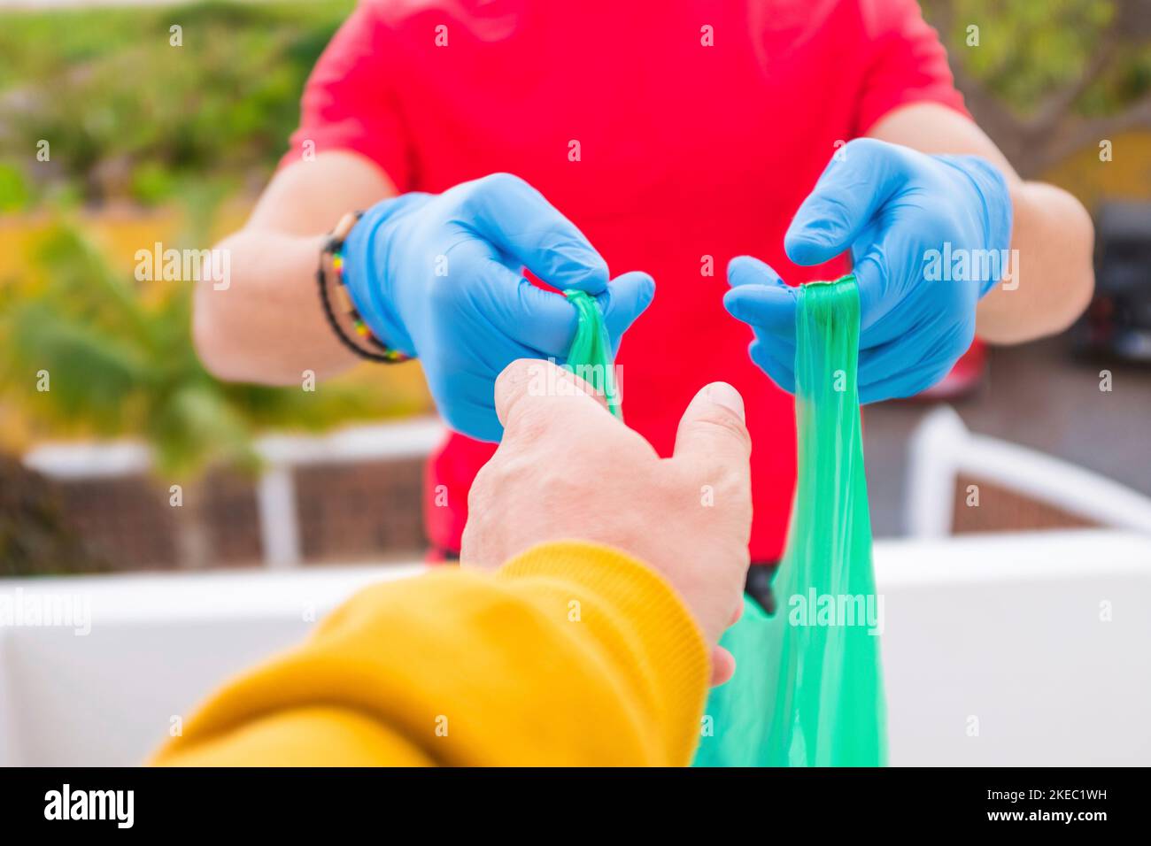 primo piano delle mani di persone povere bisogno di prendere una borsa con cibo e acqua per essere sani nella quarantena - vouluntaire uomo dare le cose a casa Foto Stock