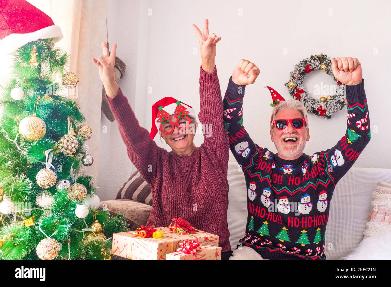 coppia di due seniors pazzo e divertente giocare divertirsi insieme e celebrare fare una festa a casa il giorno di natale prima di avvolgere i regali e i regali Foto Stock