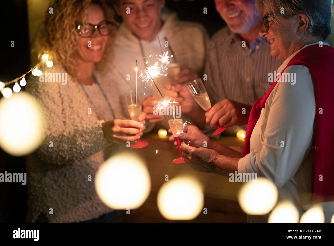gruppo di quattro persone che festeggia il 2021 insieme a sparklers e vino - divertirsi in una festa felice Foto Stock