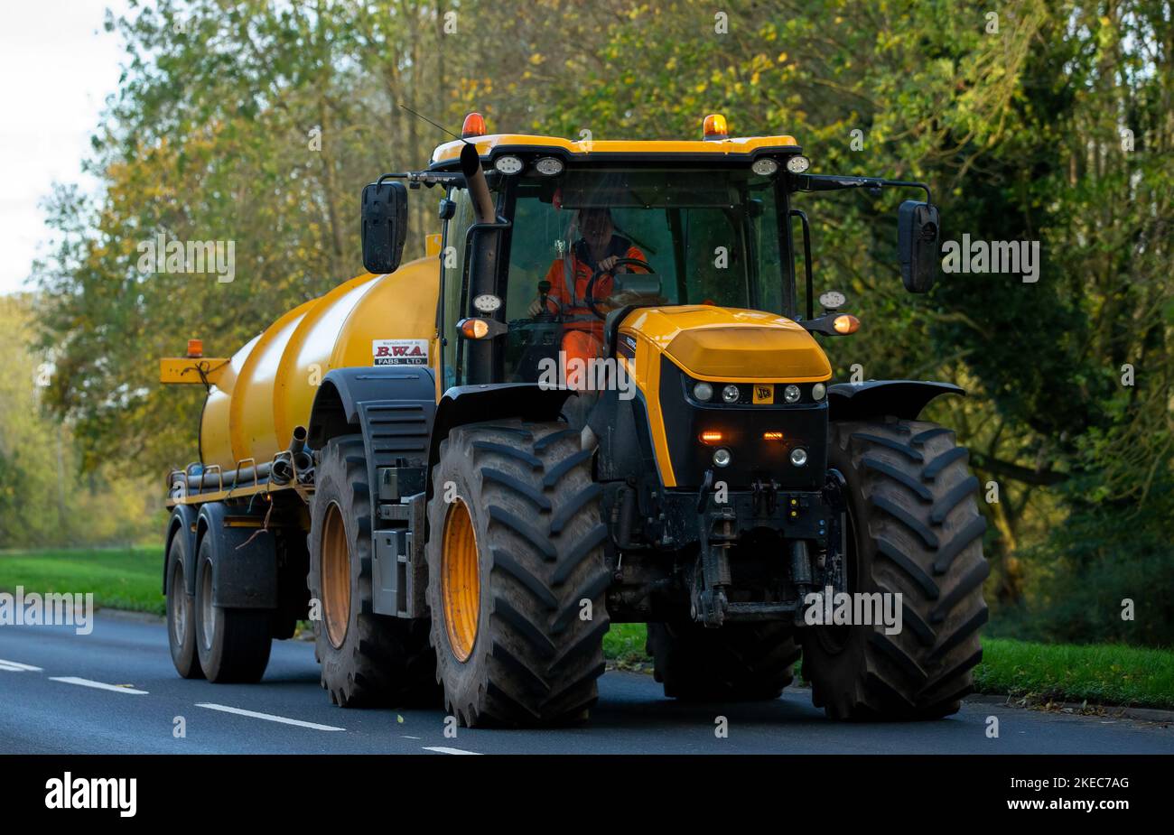 Trattore giallo JCB Fastrac che traina un serbatoio Foto Stock