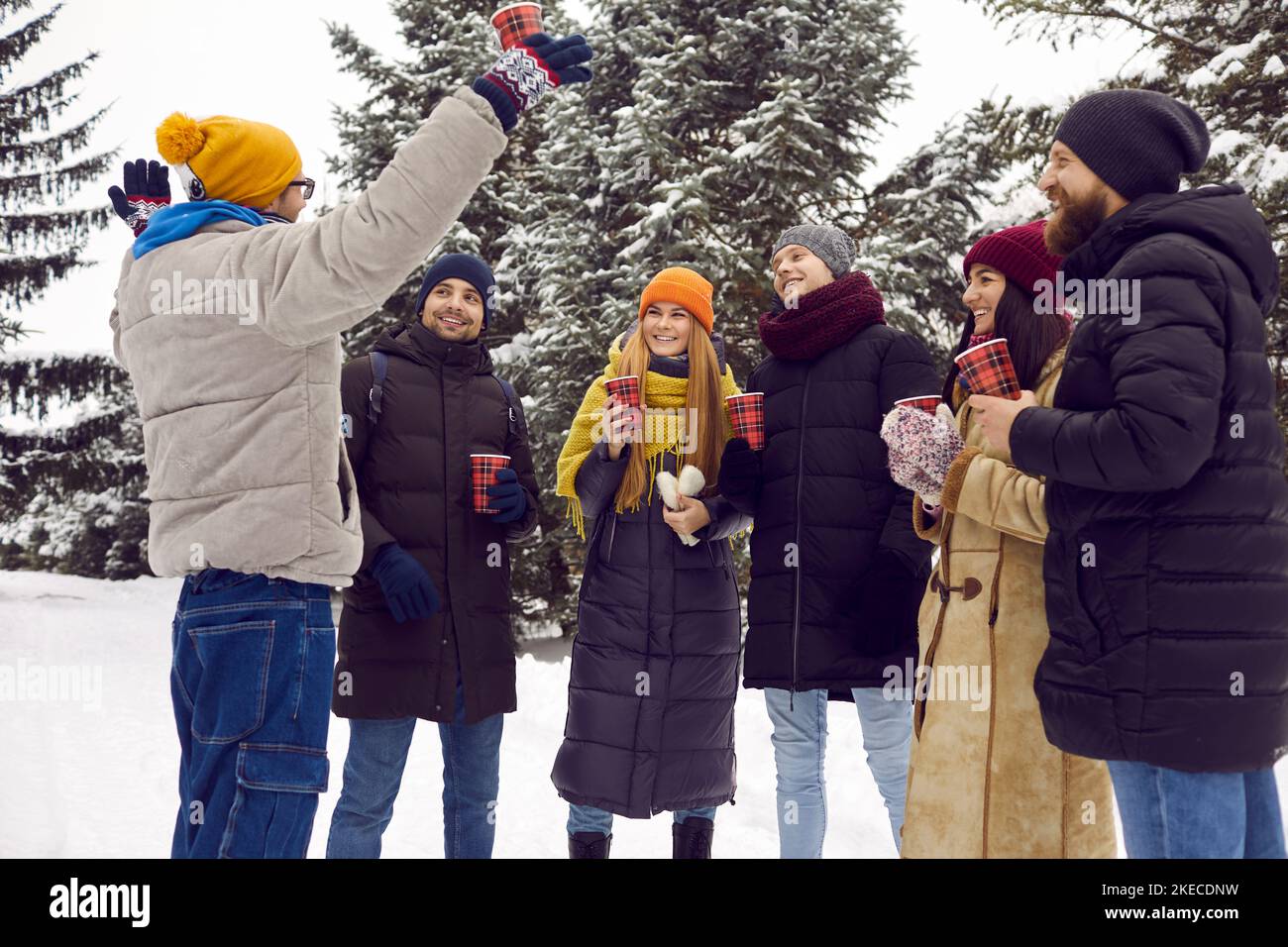 Gruppo di giovani e di giovani felici che bevono caffè e si divertono nel parco invernale Foto Stock