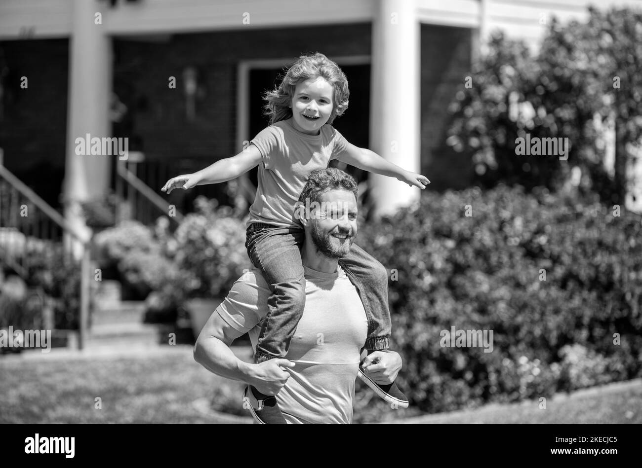 felice papà con figlio rilassarsi insieme vicino casa, famiglia europea Foto Stock