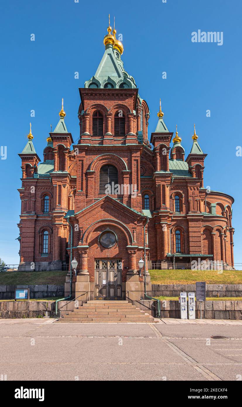 Helsinki, Finlandia - 20 luglio 2022: Cattedrale di Uspenski. Facciata in mattoni rossi del sud con torri multiple tutte sormontate da un pinnacolo dorato contro il cielo blu, AS Foto Stock