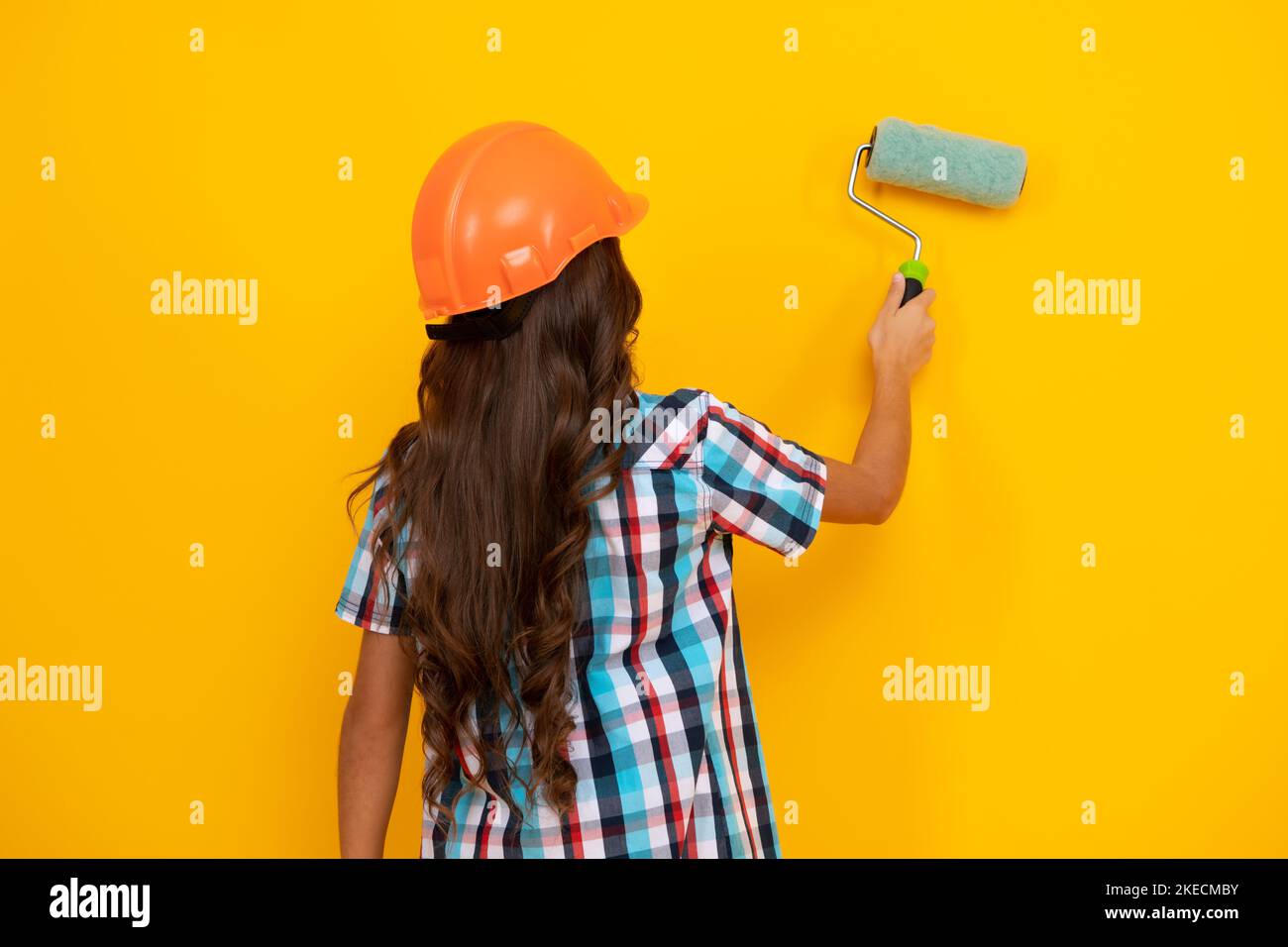 Ristrutturazione della camera per bambini. Bambina in casco protettivo e pennello per la pittura delle pareti. Foto Stock