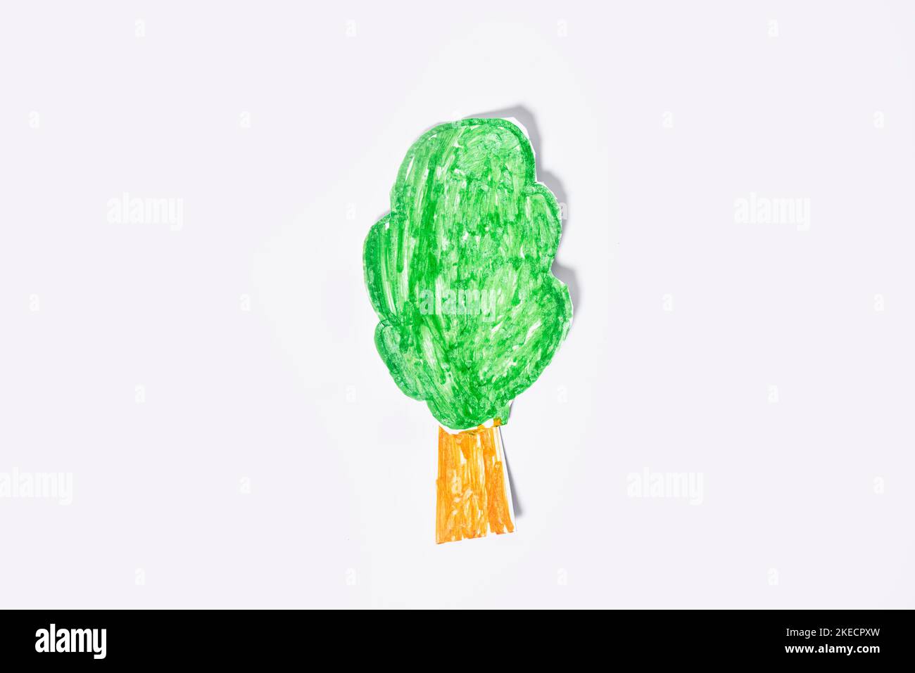 un albero fatto di carta tissue verde e arancione su sfondo bianco con un nastro arancione intorno ad esso Foto Stock