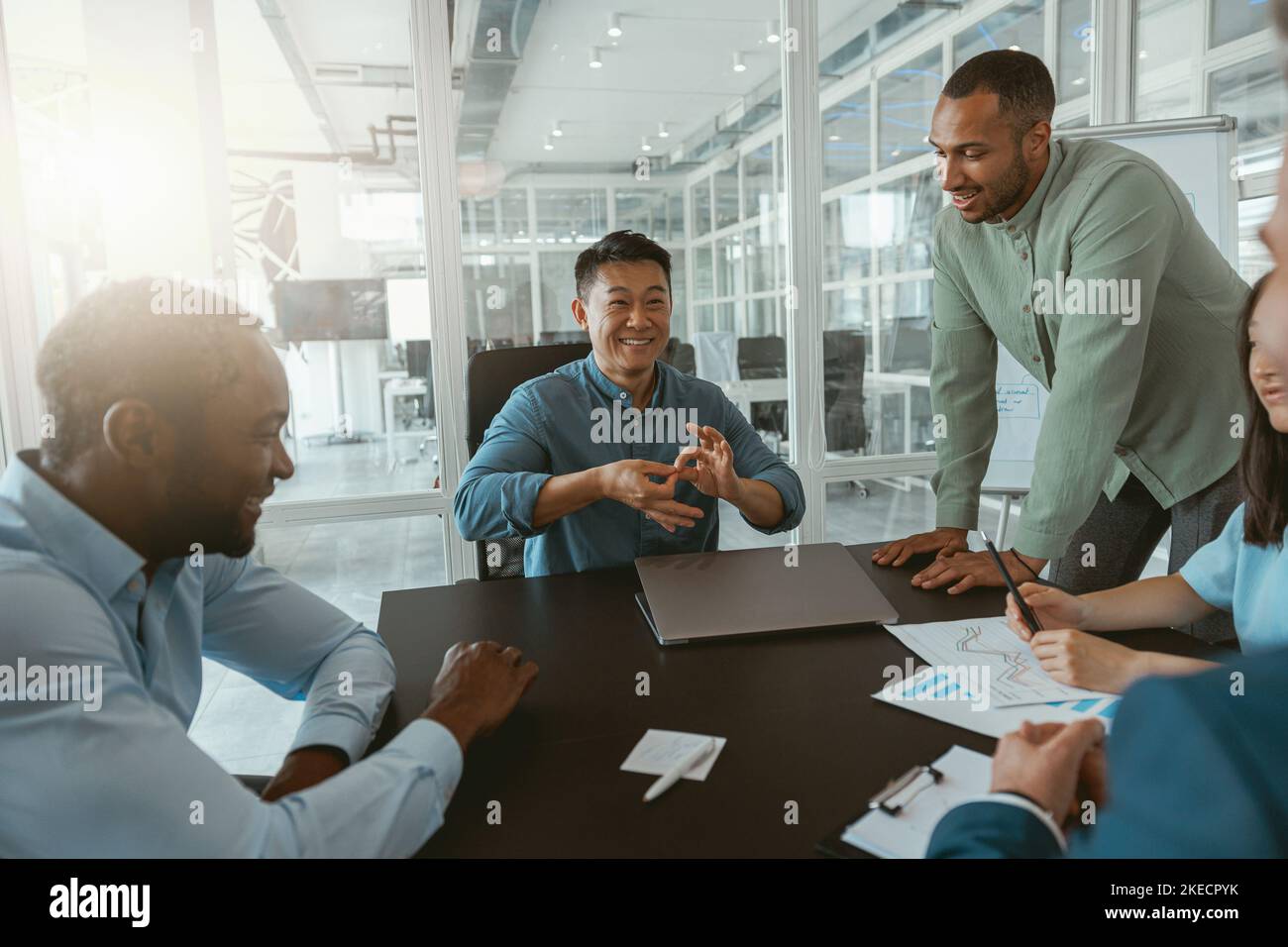 Gruppo di uomini d'affari multietnici che lavorano insieme sul progetto mentre si siedono in un ufficio moderno Foto Stock