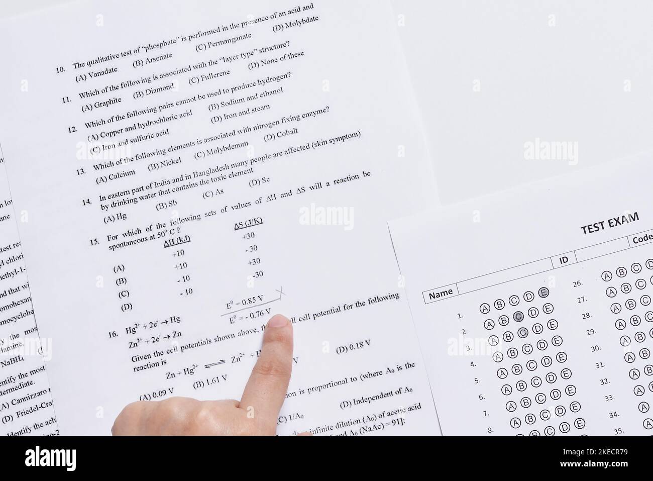 una mano di una persona che indica i numeri su un foglio di carta stampato per l'uso Foto Stock