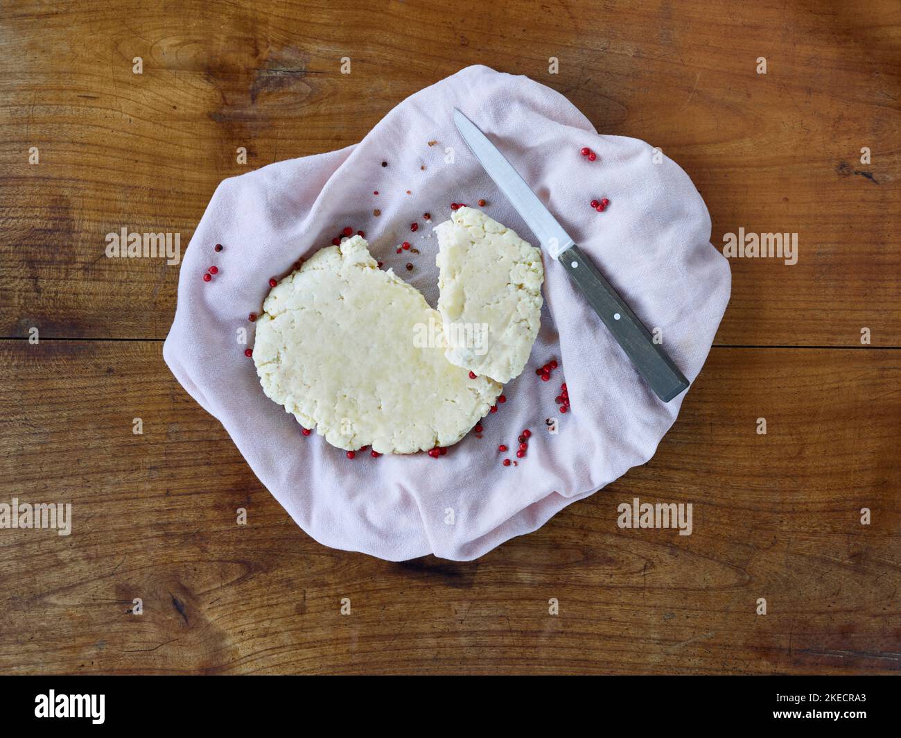 cucina ayurvedica, paneer o formaggio fresco fatto in casa in un asciugamano da cucina con coltello su un tavolo di legno Foto Stock