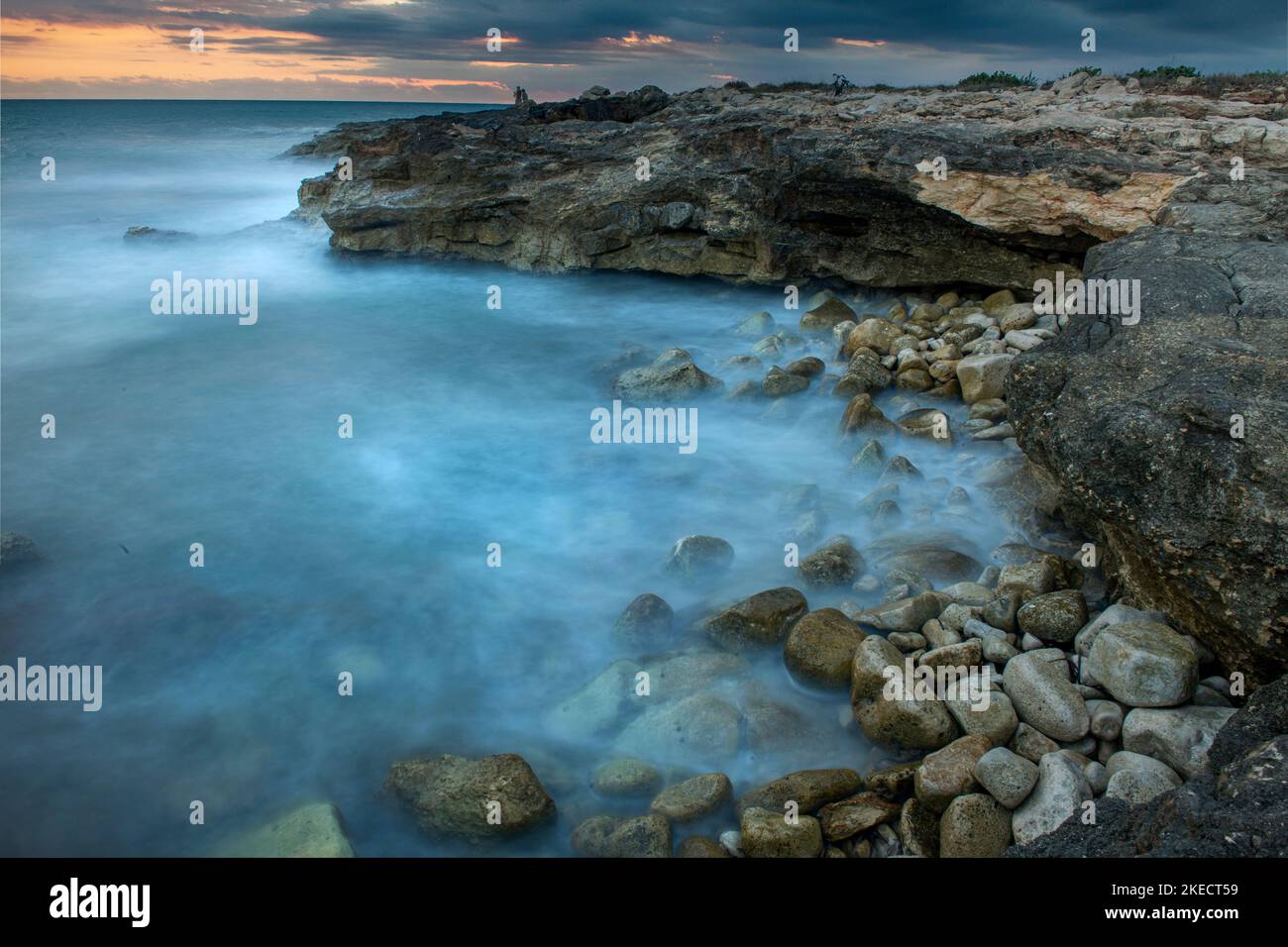 Mari accidentati sulla costa siciliana al tramonto Foto Stock