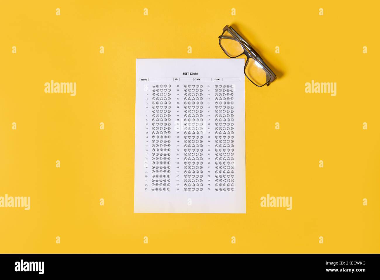 una mappa degli occhi sulla parte superiore di un foglio di carta accanto a un paio di occhiali da lettura con sfondo giallo Foto Stock