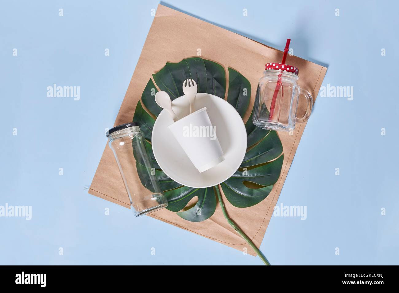 un tavolo con piatti, uts e tovaglioli sulla parte superiore del placemat di fronte a uno sfondo blu Foto Stock