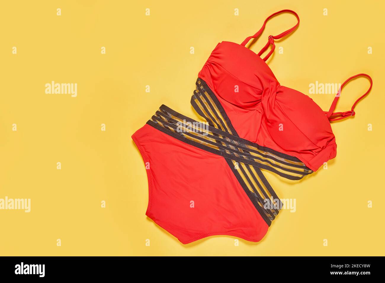 due costumi da bagno rossi, uno con fasce nere e l'altro con strisce grigie su sfondo giallo vista dall'alto Foto Stock