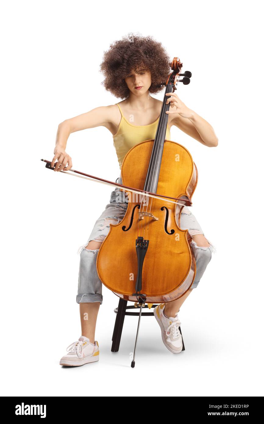 Giovane artista femminile seduto e suonando un violoncello isolato su sfondo bianco Foto Stock
