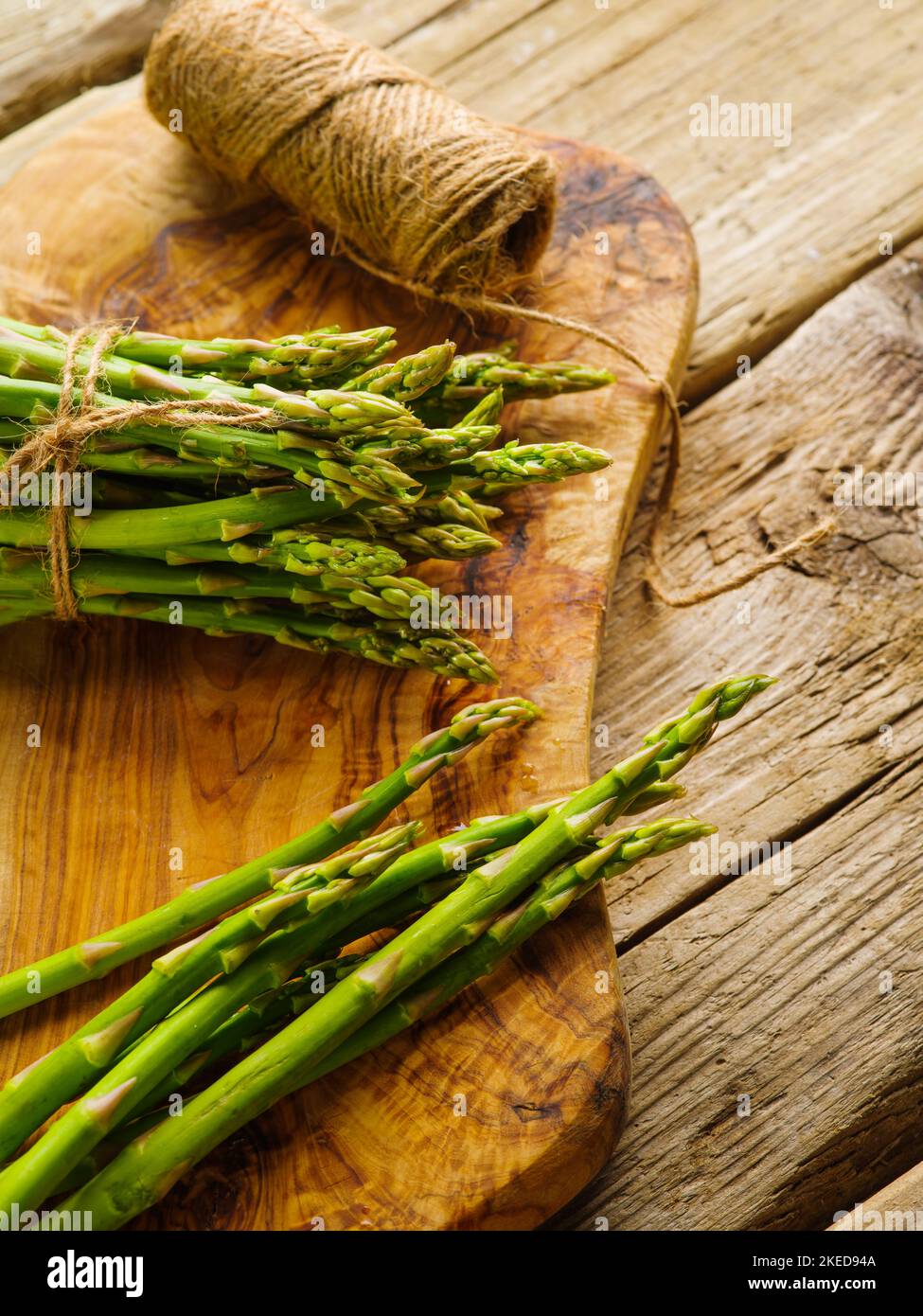 Grappoli di asparagi verdi su uno sfondo di legno. Primo piano. Vista ad angolo basso. Ristorante, hotel, cucina casalinga, blog gastronomico, ricettario. Pubblicità, divieto Foto Stock