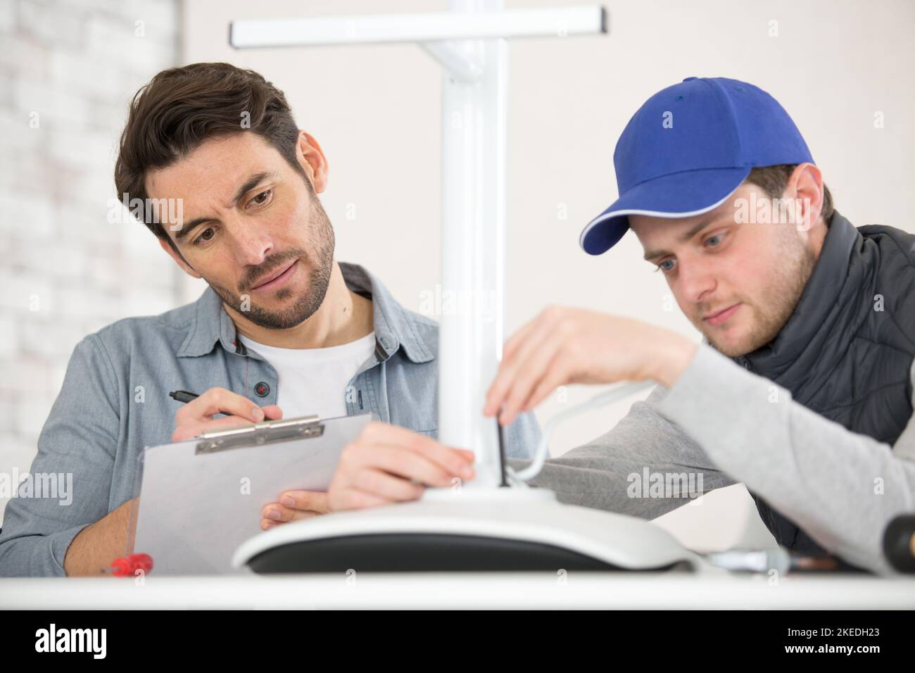 due appaltatori che lavorano su una sedia Foto Stock