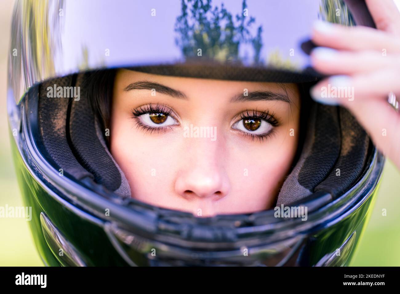 Primo piano sugli occhi di Teenage femmina Adjusting Dirt Bike casco | Moto Foto Stock
