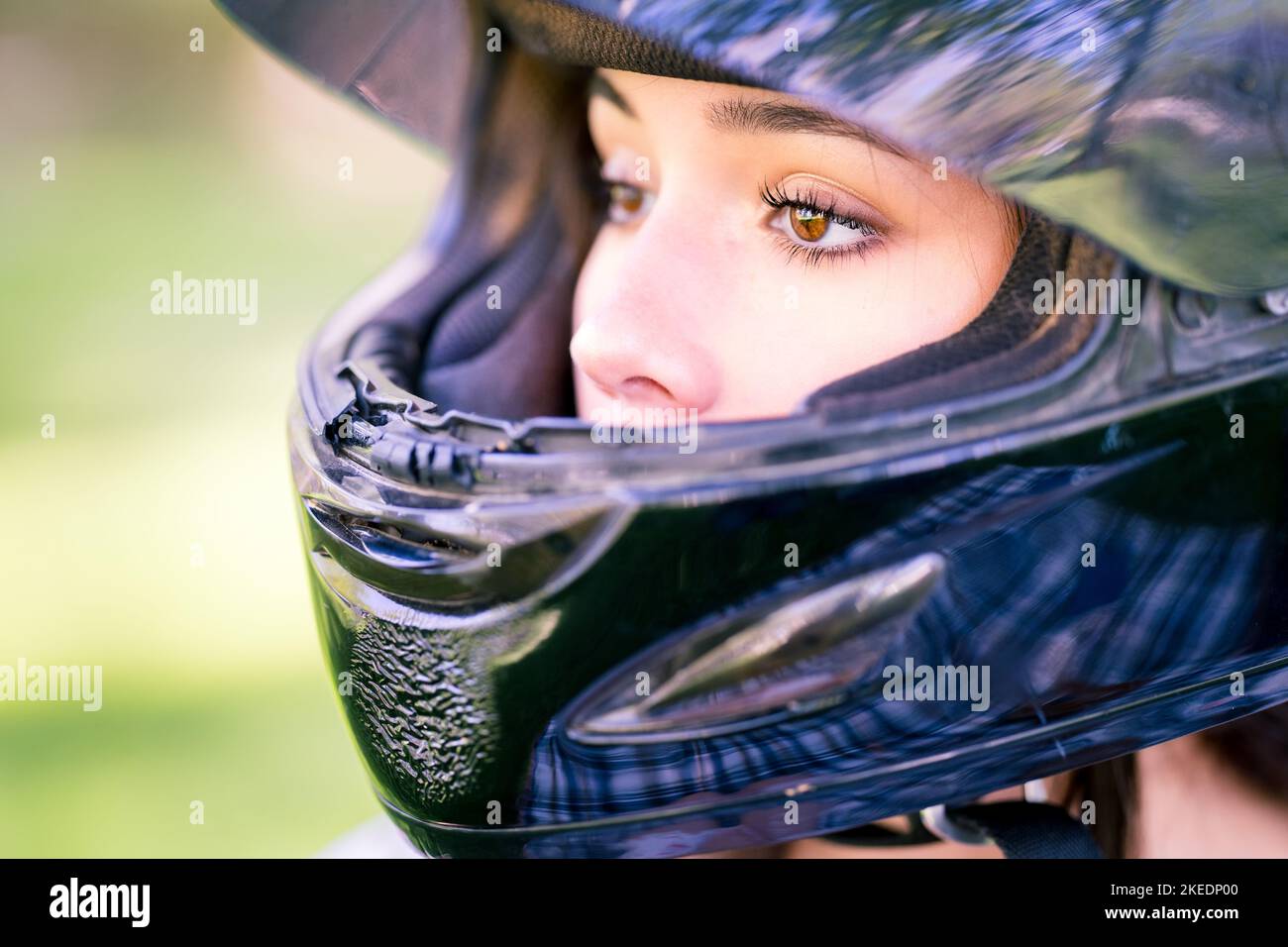 Primo piano sugli occhi di Teenage femmina Adjusting Dirt Bike casco | Moto Foto Stock