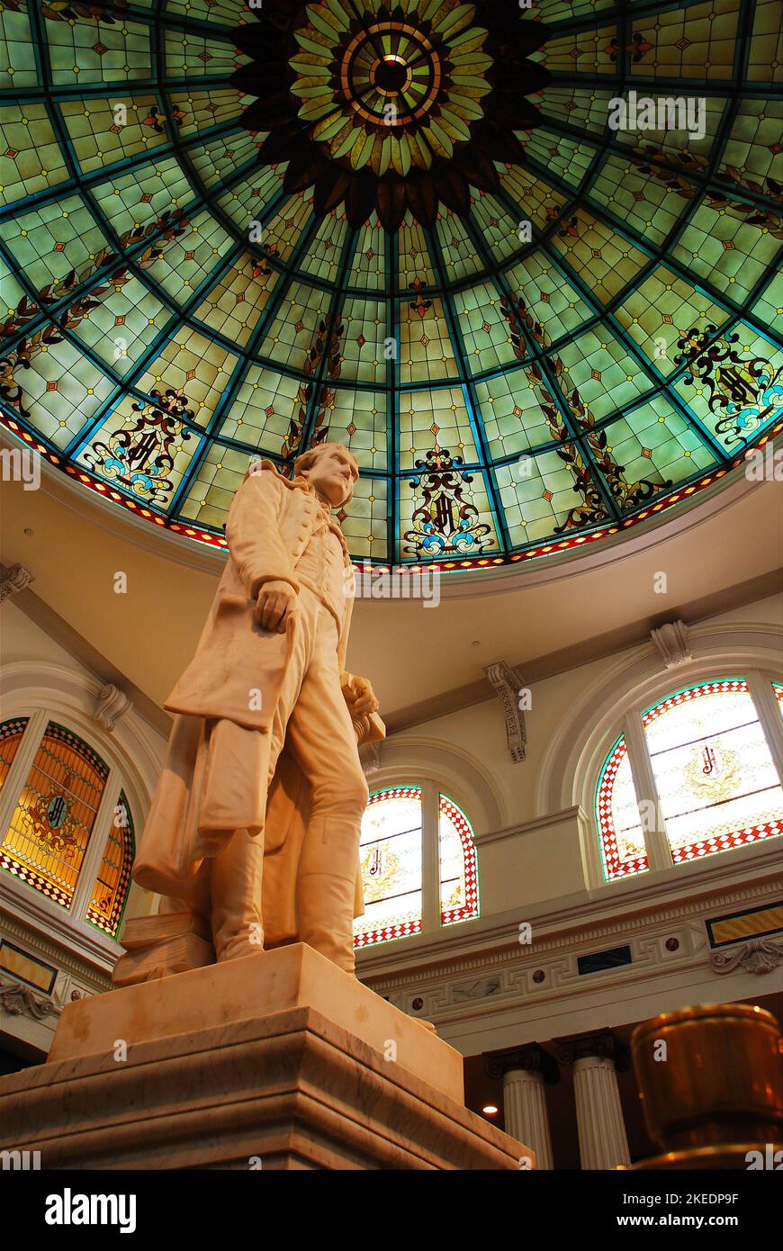 Una statua scultorea di Thomas Jefferson sorge sotto una grande finestra di vetro colorato nell'atrio della lobby del Thomas Jefferson Hotel a Richmond, Virginia Foto Stock