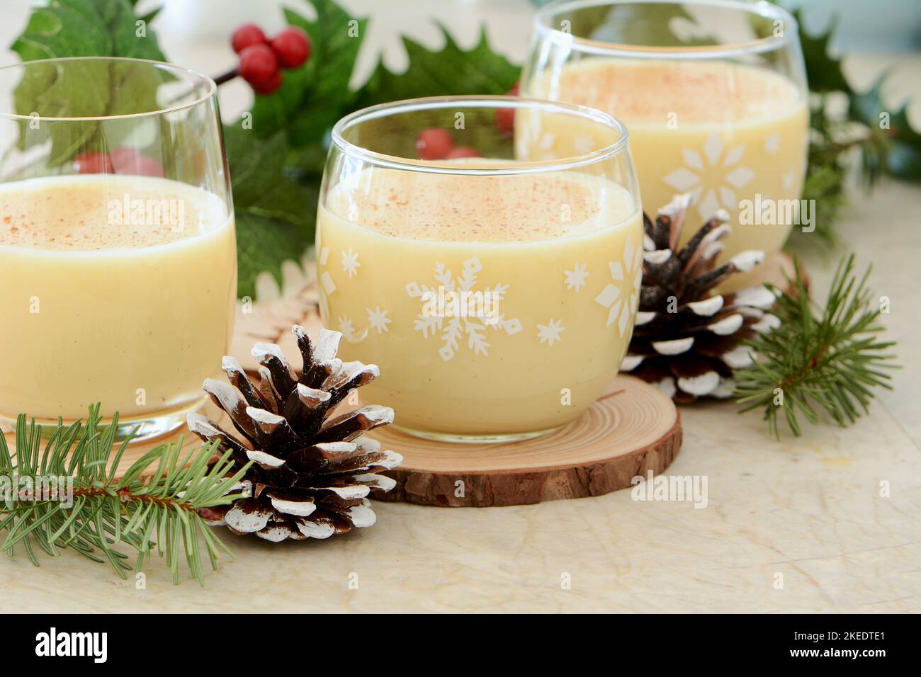 Tradizionale egnog in ambiente festivo di Natale. Formato orizzontale con messa a fuoco selettiva sul vetro centrale. Foto Stock