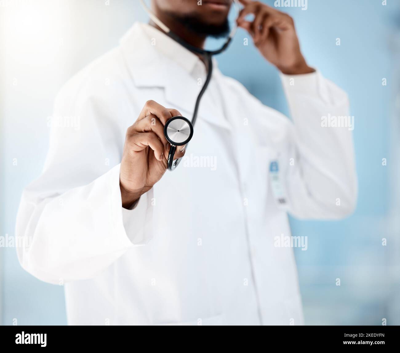 Medico, cardiologo e stetoscopio per l'assistenza sanitaria di un medico, controllo per la salute e il benessere in un ospedale. Mano dell'uomo nero che ascolta Foto Stock