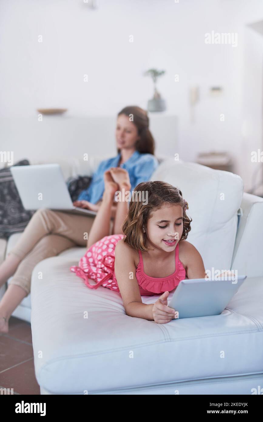 L'intrattenimento non è mai stato così breve. Una madre e sua figlia utilizzano la tecnologia wireless a casa. Foto Stock