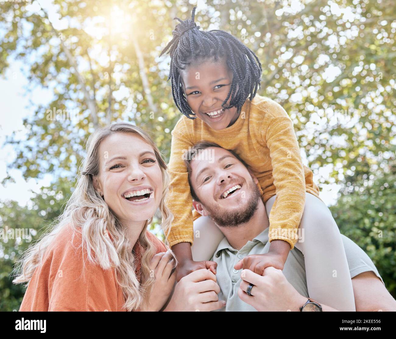 Diversità, adozione e ragazza con i genitori in un parco in estate per il sostegno, l'amore e la cura in vacanza. Felice, sorriso e ritratto di bambino africano con Foto Stock