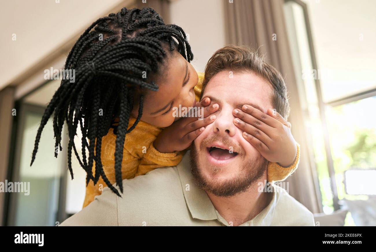 Famiglia, figli e adozione con una ragazza peekaboo e promuovere padre giocare insieme nel soggiorno della loro casa. Amore, bambini e gioco mentre un Foto Stock