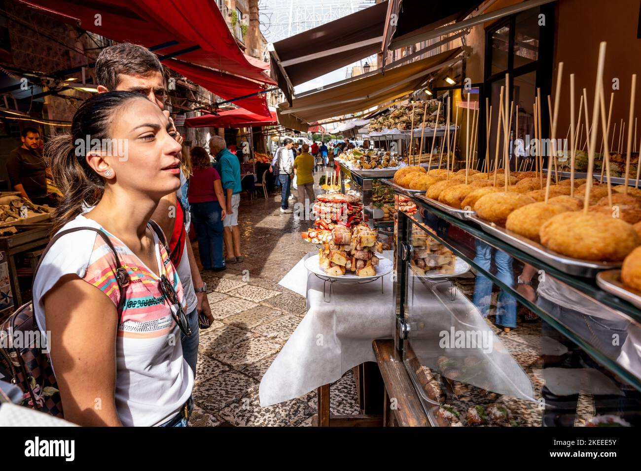 Una coppia che acquista il pranzo presso Una sosta gastronomica nel mercato di Capo (Mercado del Capo), Palermo, Sicilia, Italia. Foto Stock