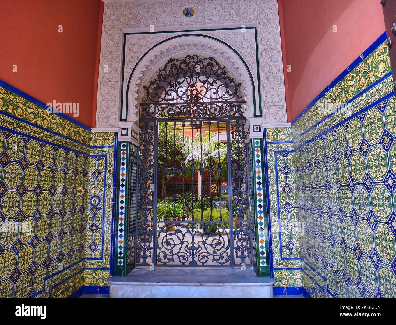 Siviglia, Spagna - 06 06 2014: Dettagli di un tipico patio spagnolo in stile mediterraneo con cancello in ferro battuto, piastrelle e fiori a Siviglia su un sole Foto Stock