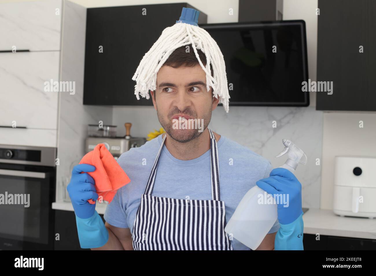 Uomo caotico che cerca di pulire la cucina Foto Stock