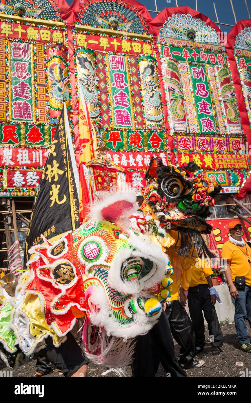 I ballerini leoni si preparano a lasciare il sito del festival da Jiu per una processione attraverso le strade della città di Kam Tin, New Territories, Hong Kong, 2015 Foto Stock