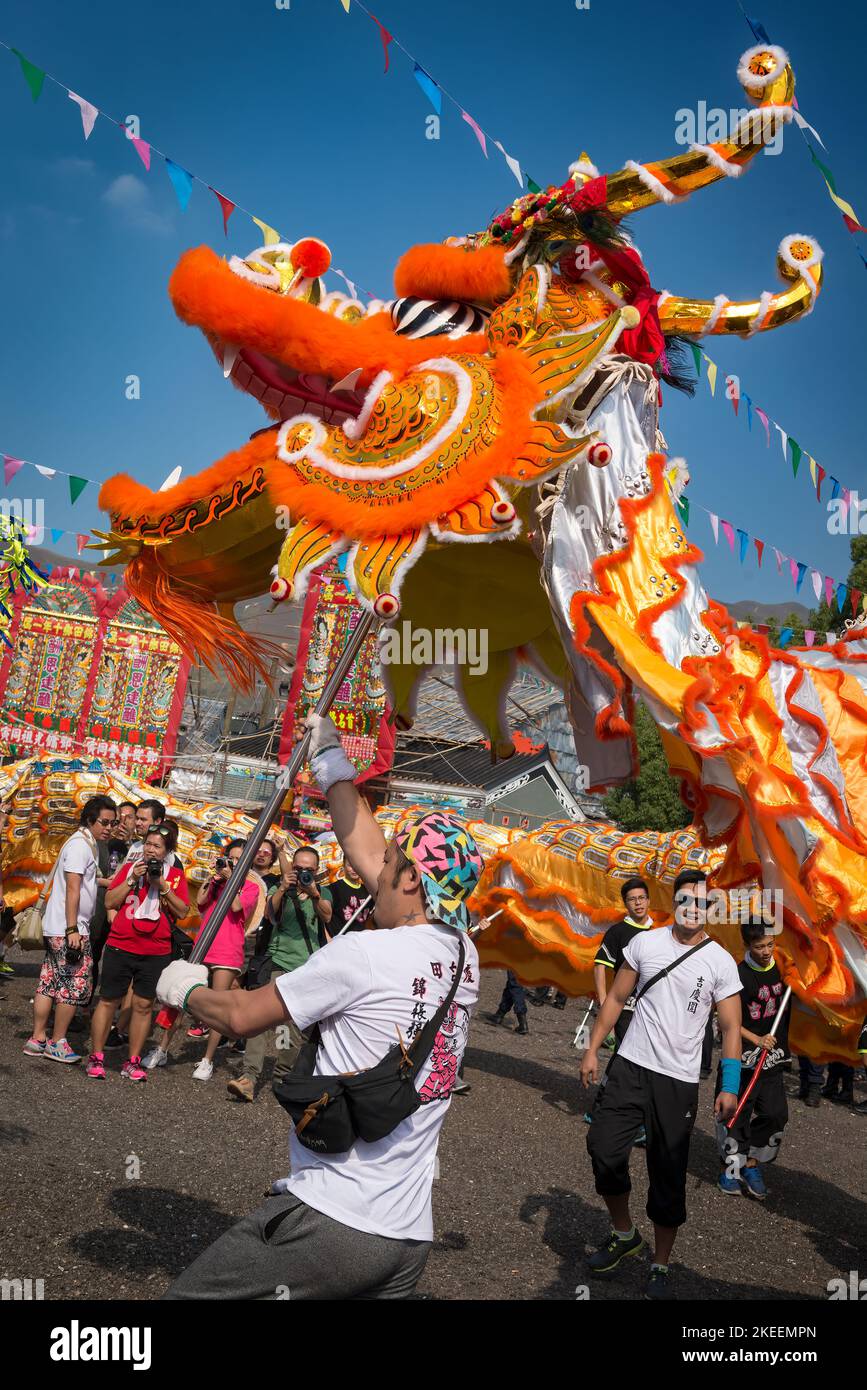 Gli abitanti del villaggio eseguono una tradizionale e colorata danza drago presso il sito decennale del festival da Jiu, Kam Tin, New Territories, Hong Kong, 2015 Foto Stock