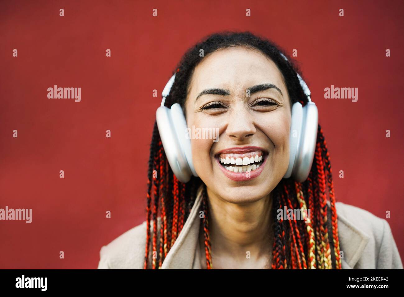 Mixed race girl ascoltare musica playlist con cuffie all'aperto - Focus on Face Foto Stock