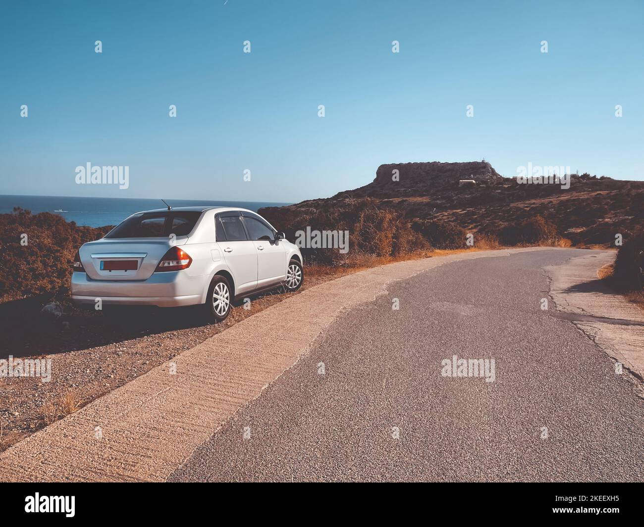 Auto bianca sulla strada del deserto di montagna. Autunno paesaggio naturale. Concetto di viaggio, turismo, vacanza, libertà e stile di vita attivo. Cipro Foto Stock