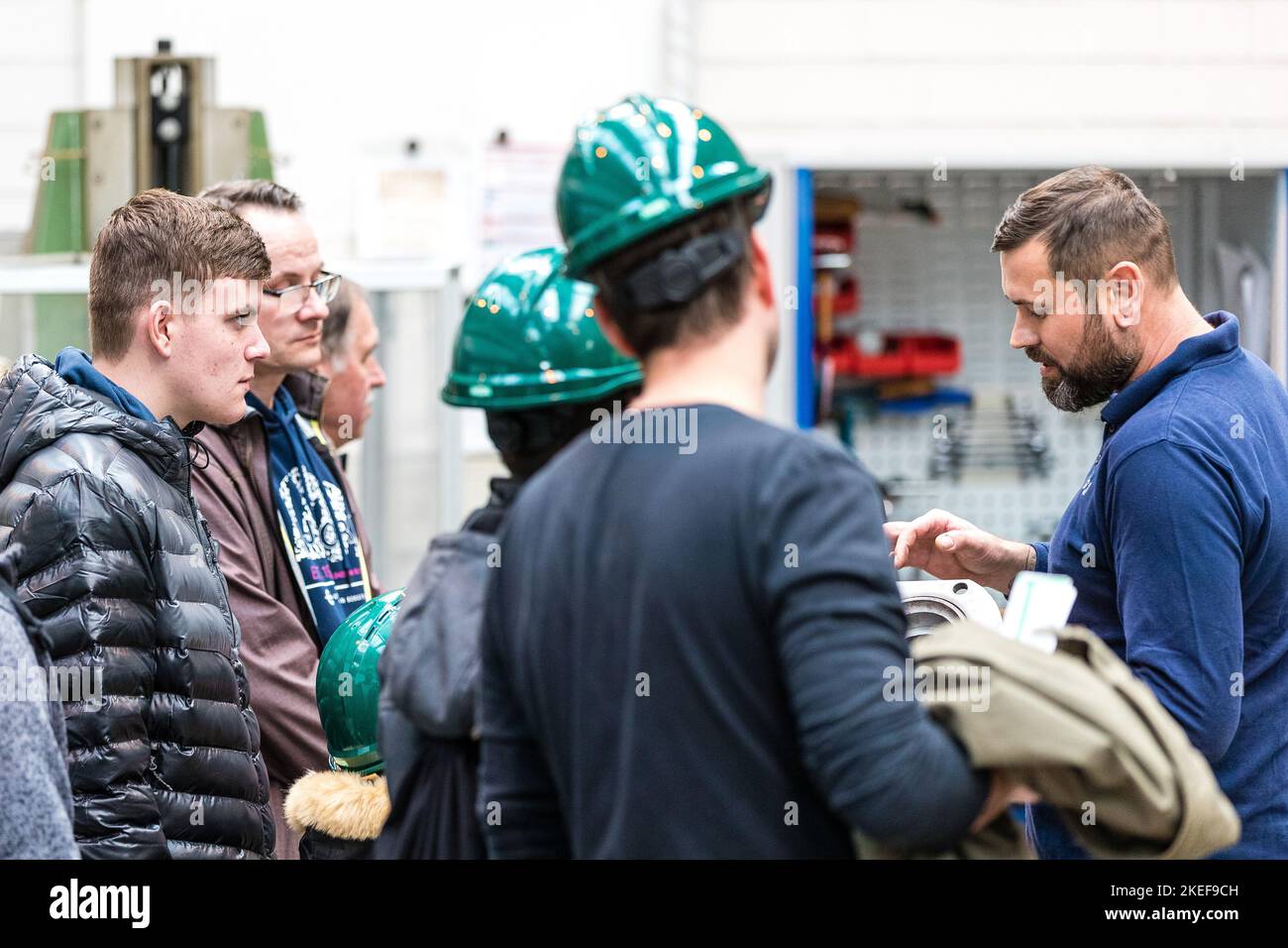 Schwarze Pumpe, Germania. 12th Nov 2022. Robert Schwedler (r) è un tecnico di lavorazione presso la Lausitz Energie Kraftwerke AG. Descrive il suo lavoro al tornio agli ascoltatori interessati. Lusatia Energie Bergbau AG e Lusatia Energie Kraftwerke AG (LEAG) stanno organizzando una giornata all'aperto nel parco industriale di Schwarze Pumpe, dove gli interessati possono guardare oltre le spalle di tirocinanti e istruttori. LEAG sta cercando di occupare 100 posti vacanti in apprendistato tecnico-industriale e commerciale, nonché in due programmi di studio duale. Credit: Frank Hammerschmidt/dpa/Alamy Live News Foto Stock