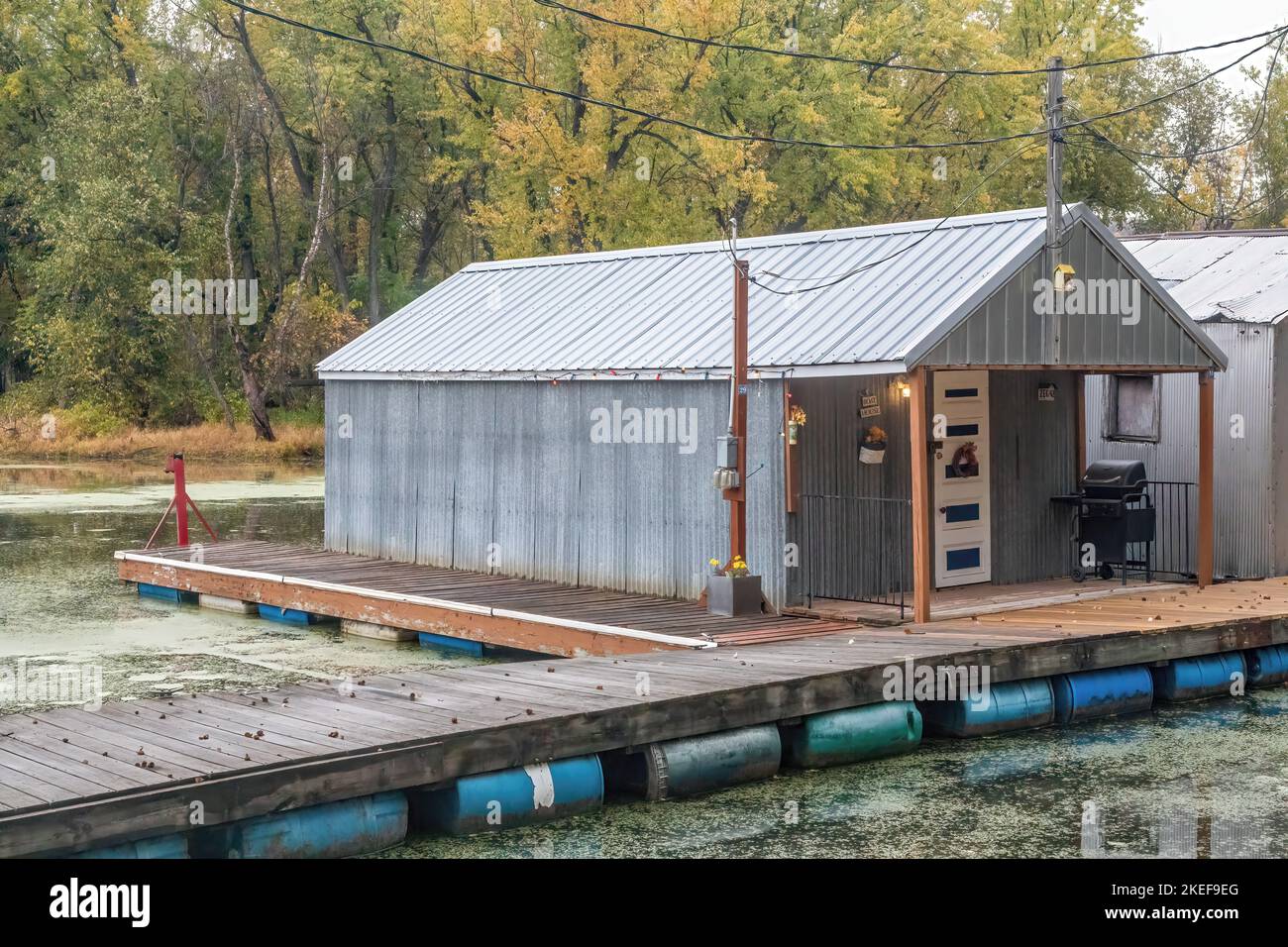 Vecchia casa di barche in alluminio o acciaio sull'isola di Latsch nelle acque posteriori del fiume Mississippi a Winona, Minnesota USA. Foto Stock