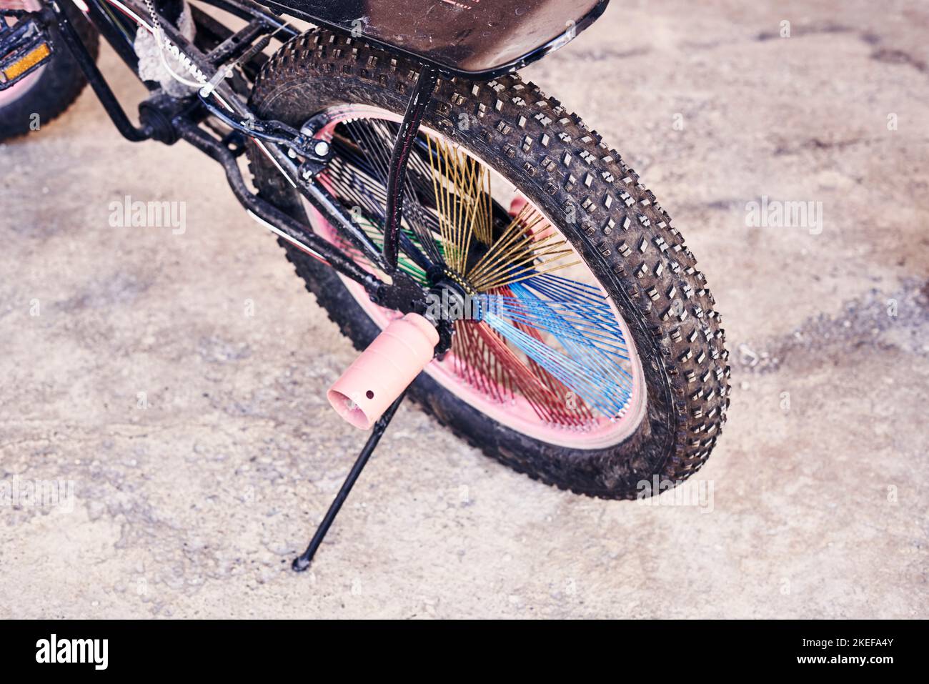 una bici sterrata parcheggiata sul lato della strada con un ombrello fissato al sedile e al manubrio Foto Stock