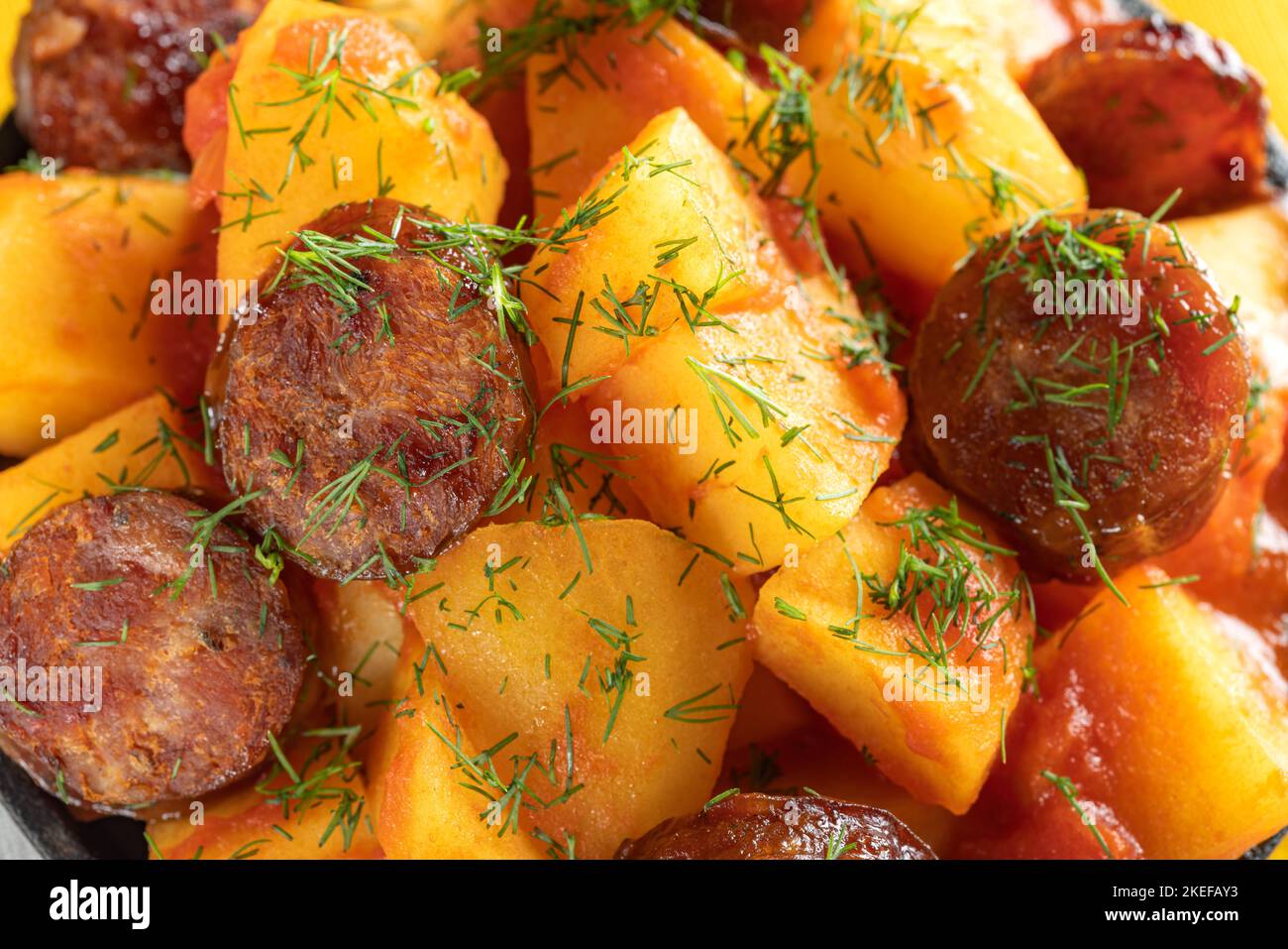 Patate con salsicce di maiale stufato in padella con erbe - vista ravvicinata Foto Stock