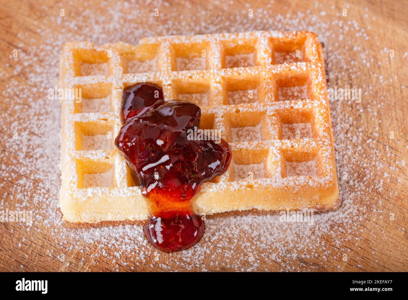 Deliziosi waffle belgi fatti in casa con marmellata di fragole e zucchero in polvere sul tavolo - vista dall'alto Foto Stock