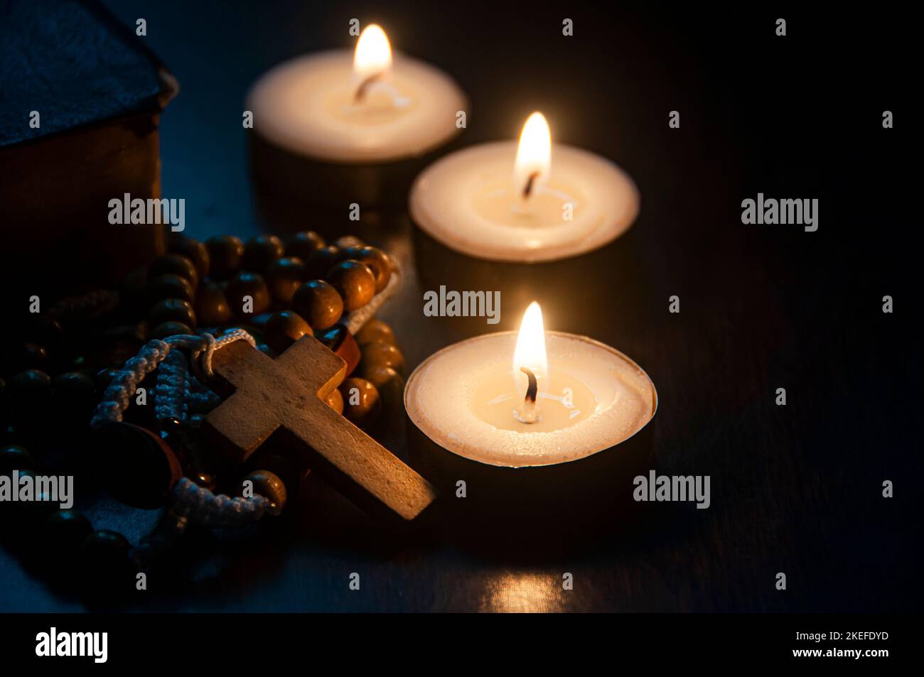 Santo Rosario, Bibbia e candele brucianti con spazio personalizzabile per testi religiosi o idee. Copiare spazio e concetto di religione. Foto Stock