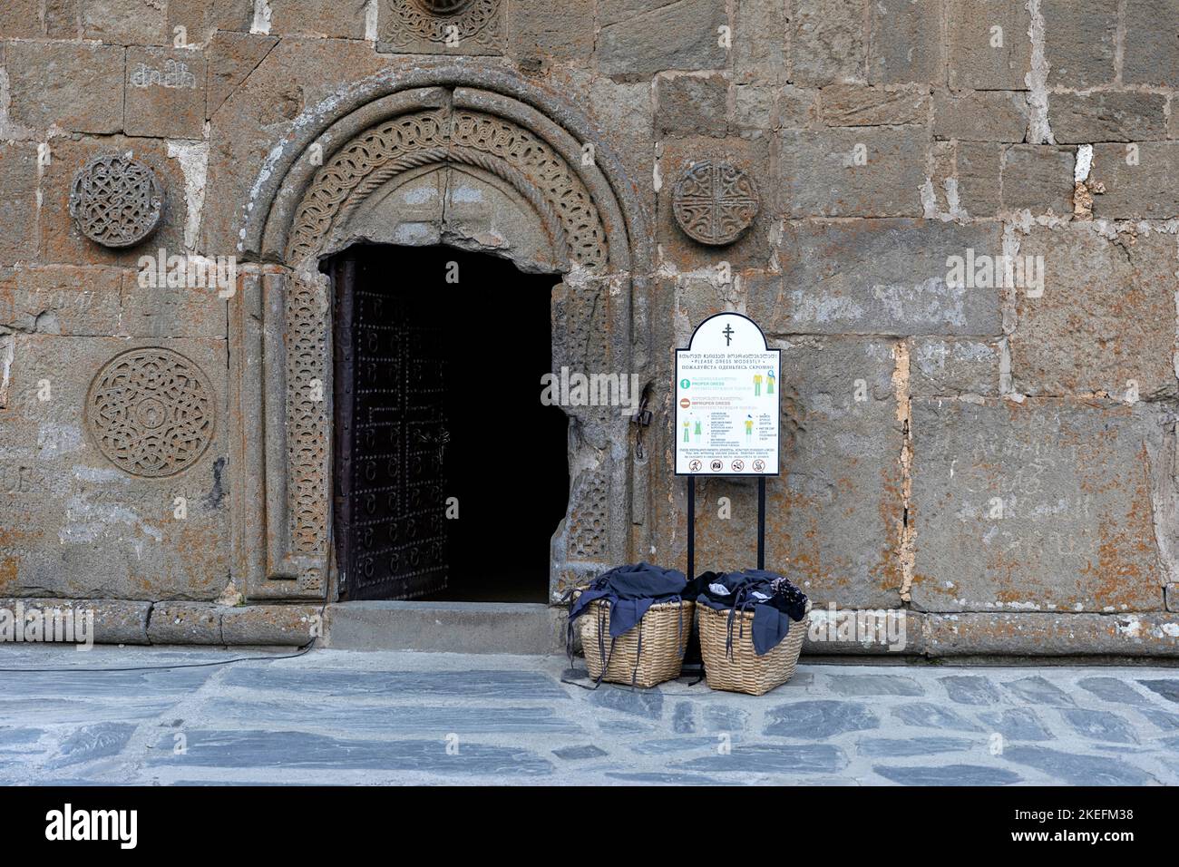 Cestino con foulard per le donne per coprire i capelli all'ingresso della Chiesa della Trinità di Gergeti, Kazbegi, Georgia, Europa Foto Stock