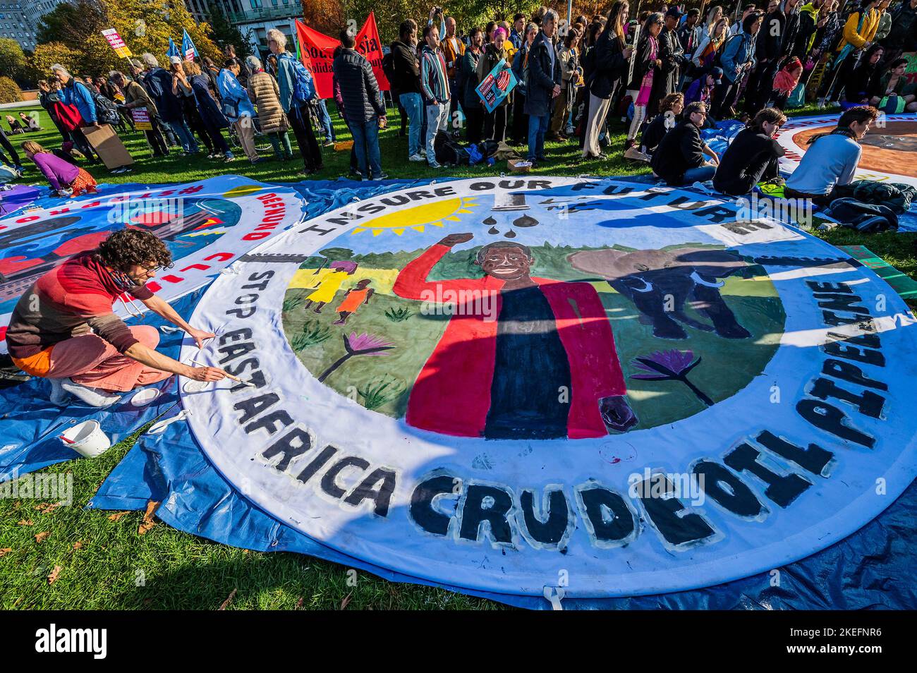 Londra, Regno Unito. 12th Nov 2022. Gli attivisti delle riparazioni climatiche Bloc e Defund Climate Chaos dipingono opere d'arte su larga scala (n Jubilee Gardens di fronte all'edificio Shell), come chiedono: 1) interrompere l'assicurazione e il finanziamento dei progetti sui combustibili fossili 2) arrestare il gasdotto petrolifero dell'Africa orientale (EACOP) e arrestare il giacimento petrolifero di Rosebank, 3) ristrutturazioni climatiche per le comunità di tutto il mondo. i Credit: Guy Bell/Alamy Live News Foto Stock