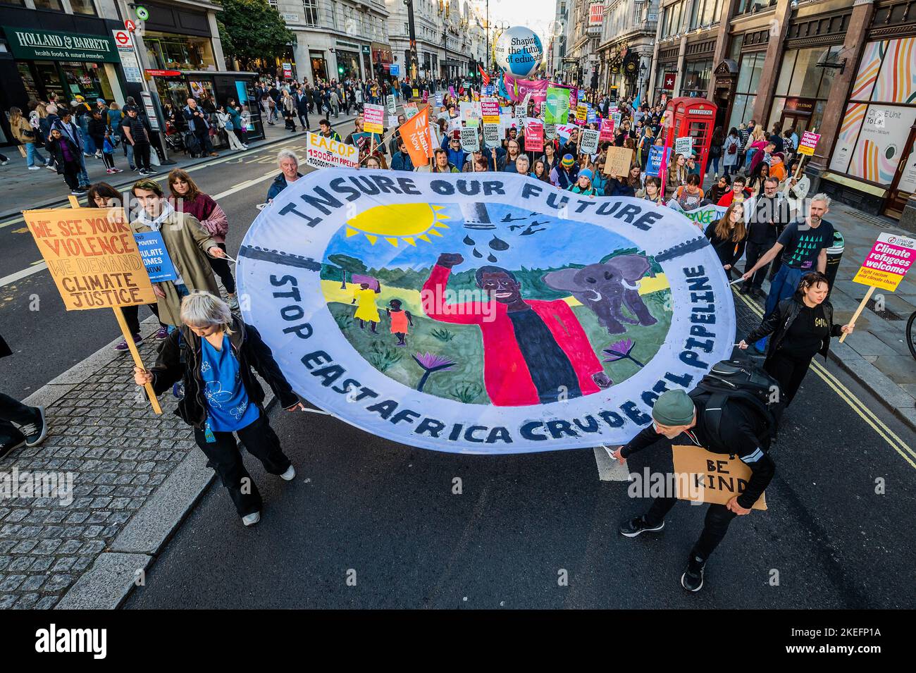 Londra, Regno Unito. 12th Nov 2022. Banner completi si uniscono a na clima marcia a Trafalgar Square - attivisti dal clima riparazioni Bloc e Defund clima Chaos pittura di grandi opere d'arte su larga scala (n Jubilee Gardens di fronte alla Shell Building), come chiedono: 1) interrompere l'assicurazione e il finanziamento dei progetti sui combustibili fossili 2) arrestare il gasdotto petrolifero dell'Africa orientale (EACOP) e arrestare il giacimento petrolifero di Rosebank, 3) ristrutturazioni climatiche per le comunità di tutto il mondo. i Credit: Guy Bell/Alamy Live News Foto Stock