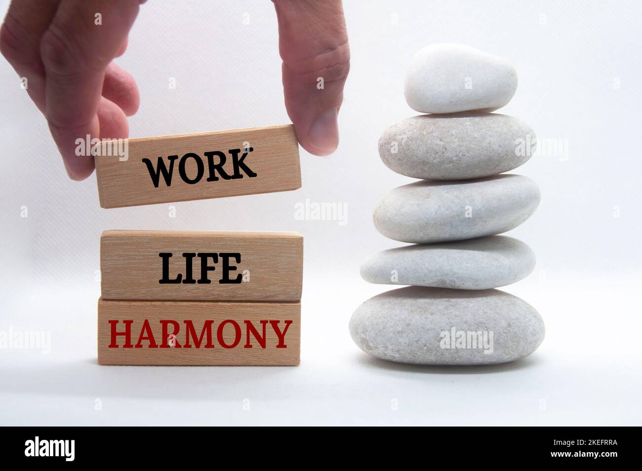 Testo dell'armonia della vita lavorativa su blocchi di legno con sfondo in pietra zen. Concetto di cultura del lavoro. Foto Stock