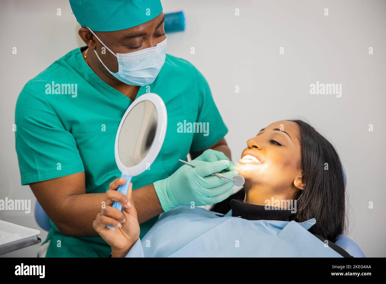 Il paziente guarda i denti con lo specchio durante una visita dentale. Foto Stock